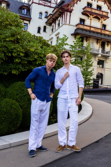 Zwei Models in ELEVÉ Looks vor der Fassade eines historischen Hotels