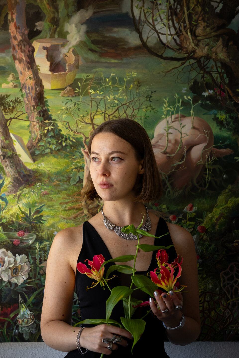 Gast mit Blumen vor einem farbenfrohen Gemälde an der Vernissage